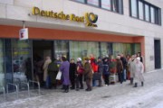 Menschenschlangen vor einem Postamt in München bei klirrender Kälte